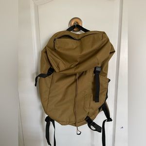REI Co-Op tan backpack with water bottle holder